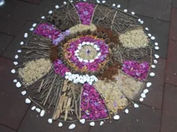 Natürliche Mandala mit Zweigen, Blumen und Steinen."